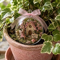 Miniature fairy garden fillable ornament craft idea featuring a whimsical fairy cottage for home décor, flower pots, and magical garden displays.